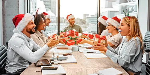 Colleghi che si scambiano piccoli regali di Natale durante un Secret Santa organizzato in ufficio.